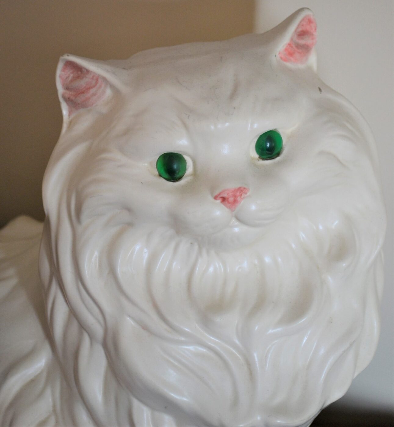 A white porcelain cat with green eyes.